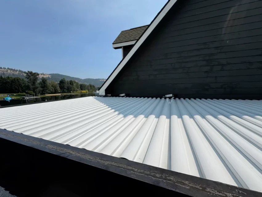 White corrugated metal roof cleaned above a lakefront home